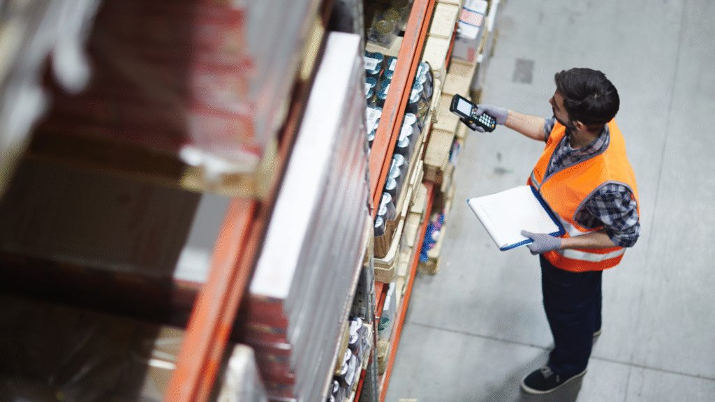 Warehouse operative in hi-vis checking stock with a tablet