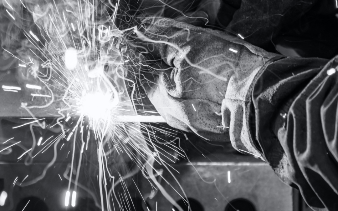 Fabricator welding with sparks flying