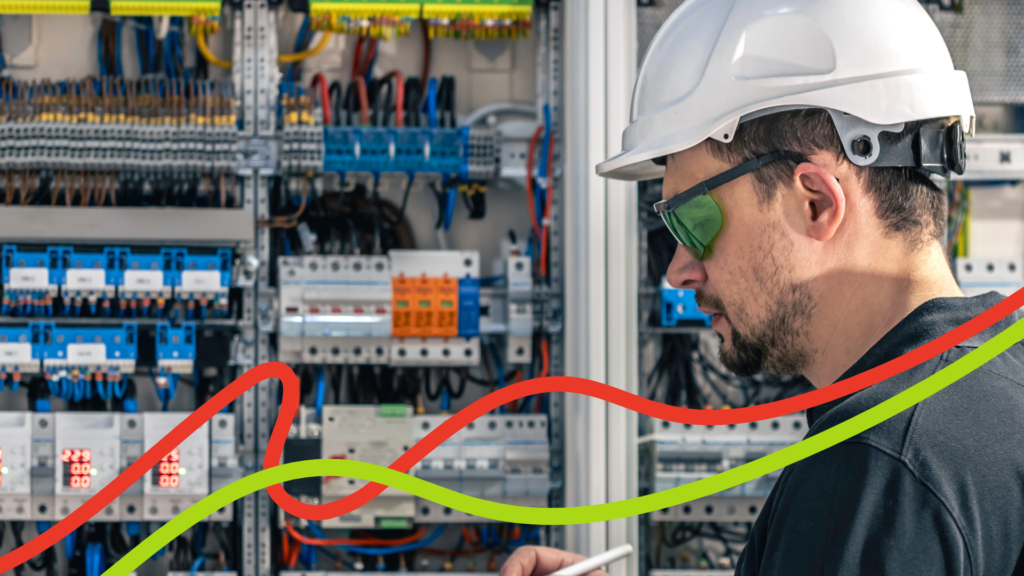 Electrical maintenance engineer in a hard hat working on a control panel