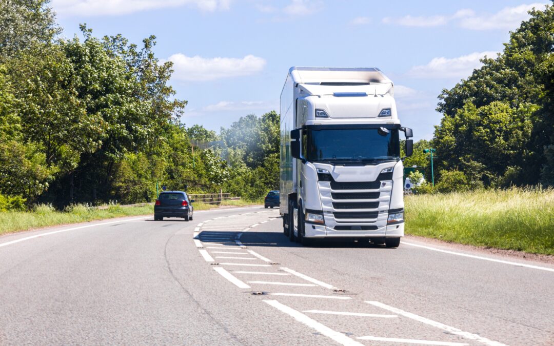 White HGV Class 1 lorry driving on a UK country road