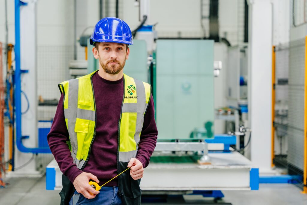 Engineer in a hard hat and hi-vis working on a UK site